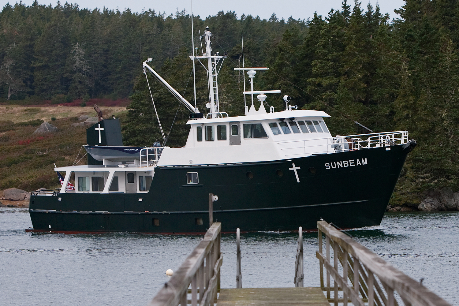 Color photo of Maine Seacoast Mission's current boat, Sunbeam V, on the water near an island