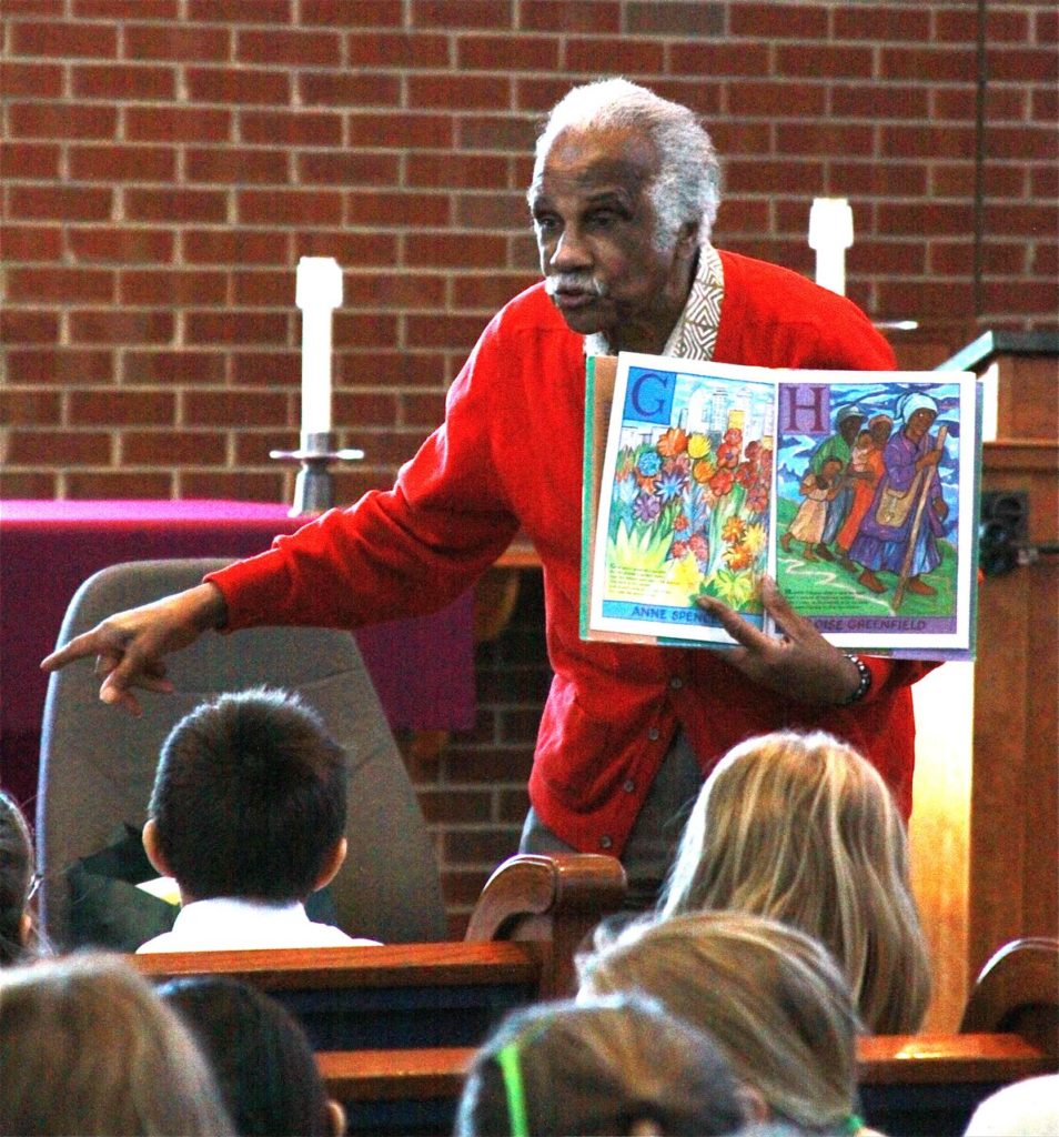 American artist and author Ashley Bryan reads aloud to an audience of children on the Maine island of Islesford.