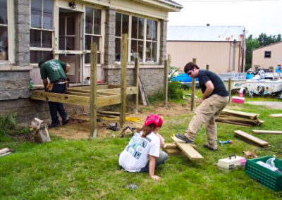 Color photo of Housing Rehab program volunteers build house steps on a lawn