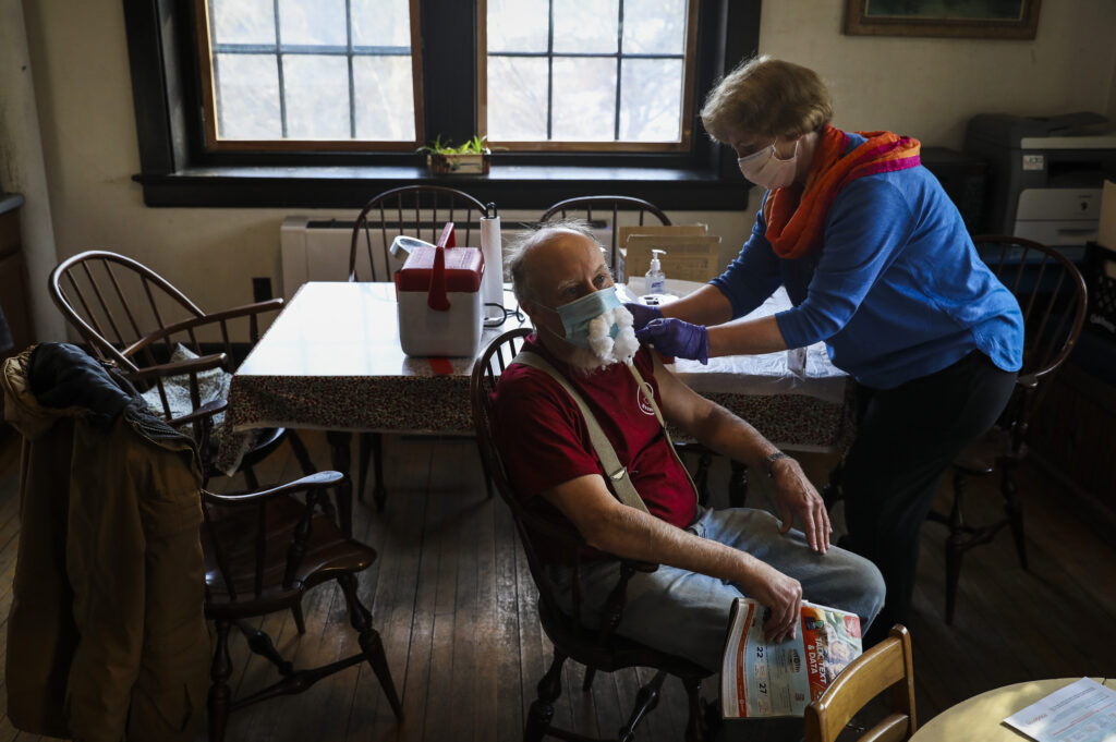 Isle au Haut resident Mike Fedosh, who received his vaccine from RN Maureen Giffin, glued cotton balls to his mask to represent the mustache he has underneath.