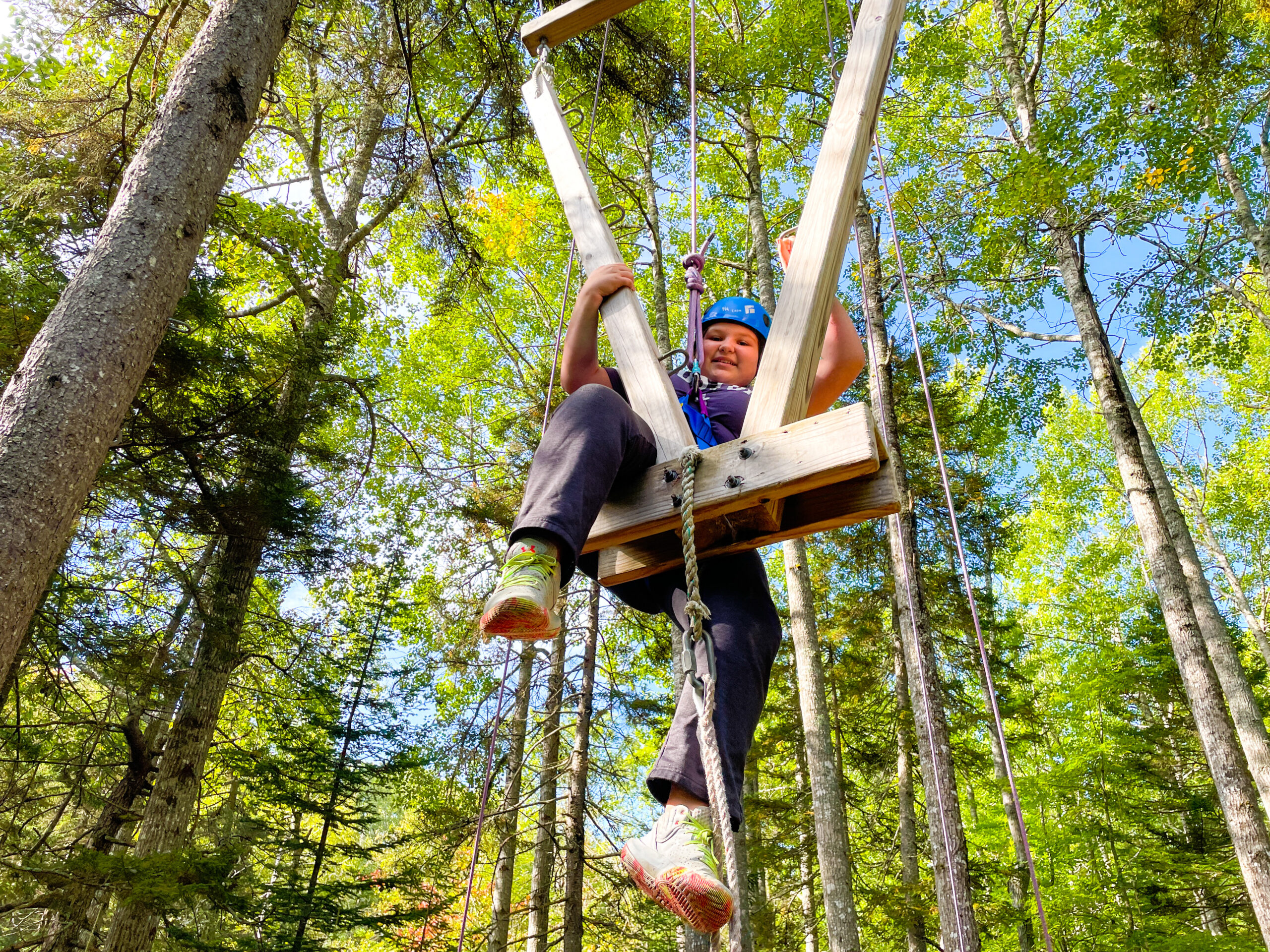 Color photo of student on the ropes course