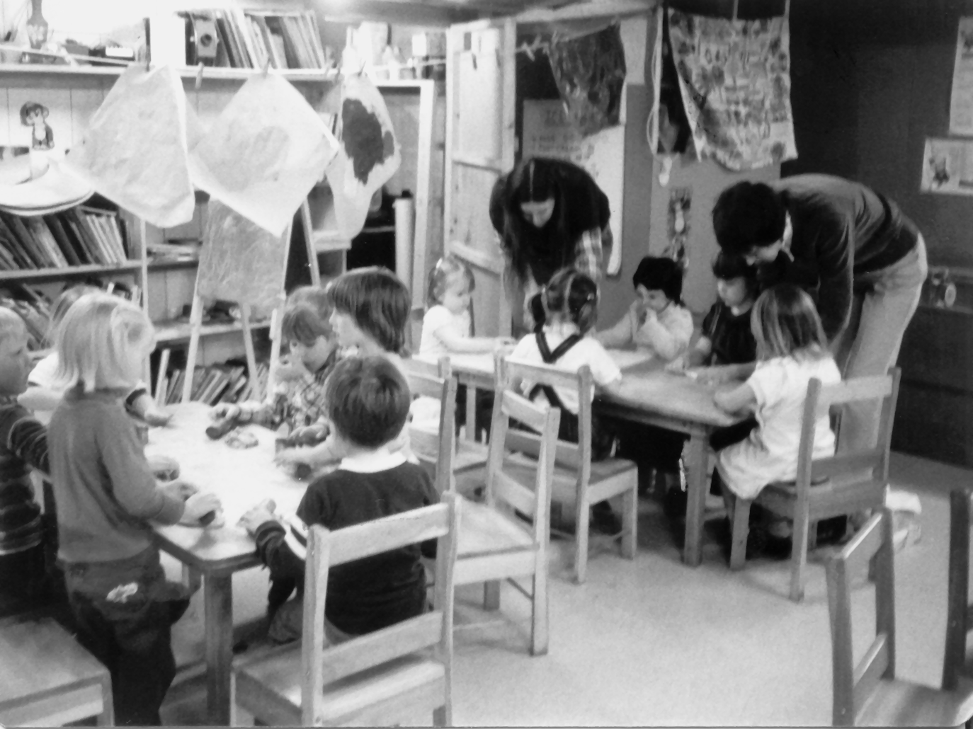 A black and white photo of students and adults working on an art project