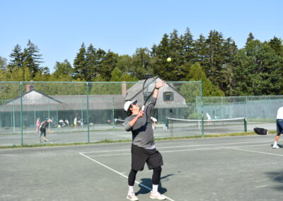 A color photo of a man hitting a tennis ball