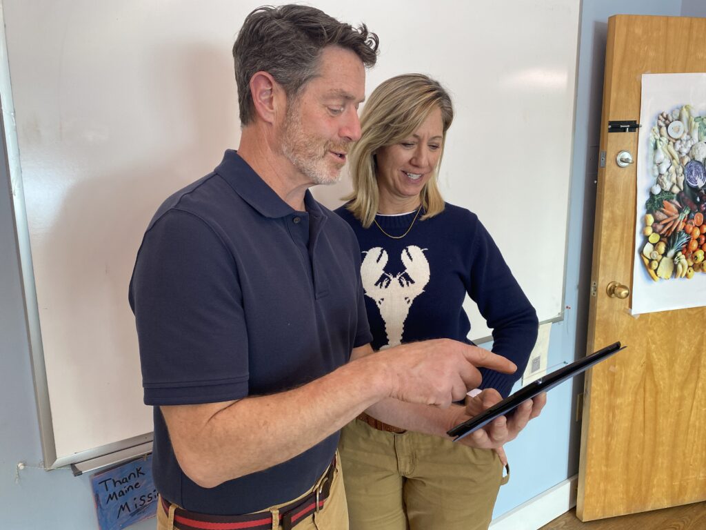 Two people look at an iPad