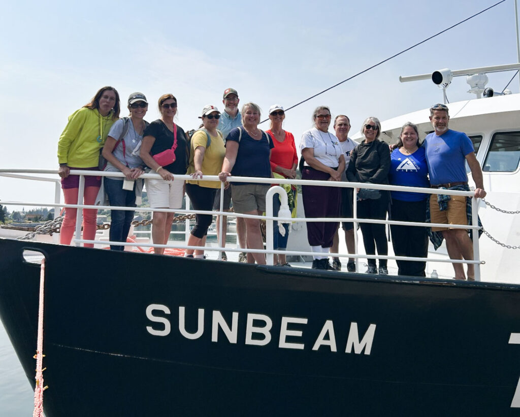 A group of people stand on the bow of the Sunbeam 