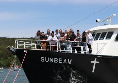 A group of younger women stand on the bow of the Sunbeam