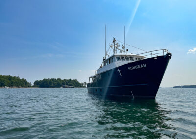 Photo of Sunbeam's bow faces the camera as it moors in sunny Casco Bay waters