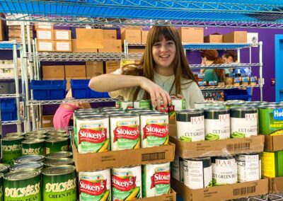 A sister from Sigma Kappa helps stock the pantry shelves during a week-long service trip to Downeast Maine and on outer islands.