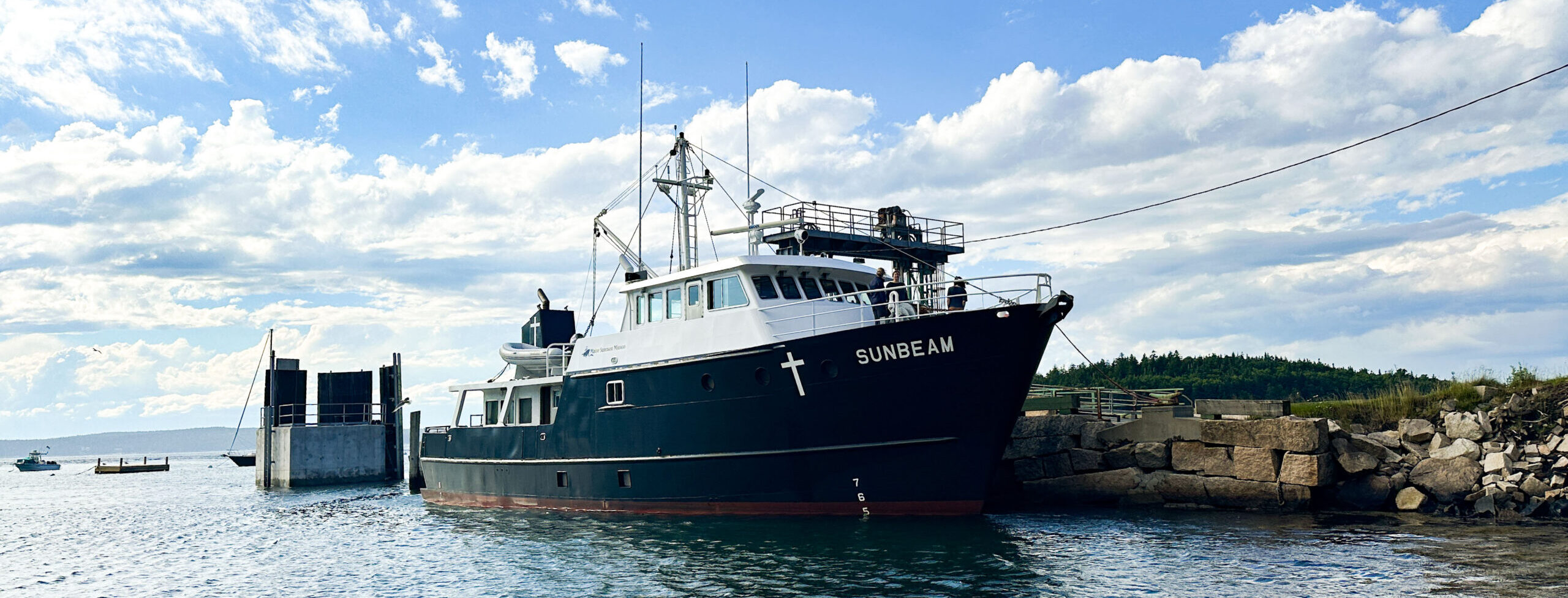 A picture of the Sunbeam boat docked on Frenchboro. The boat is seen from far away.