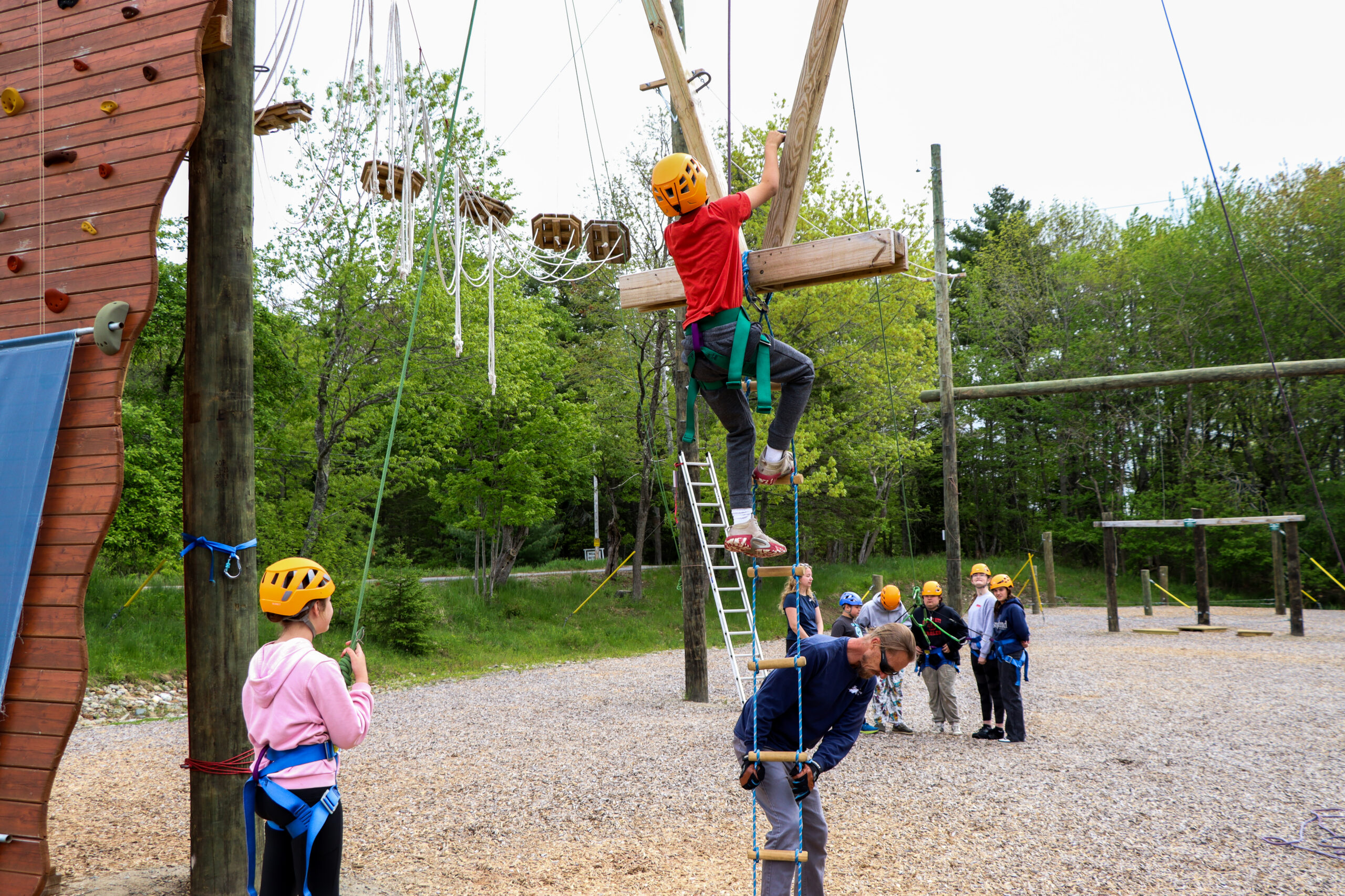 Staff member helping students on Challenge Course