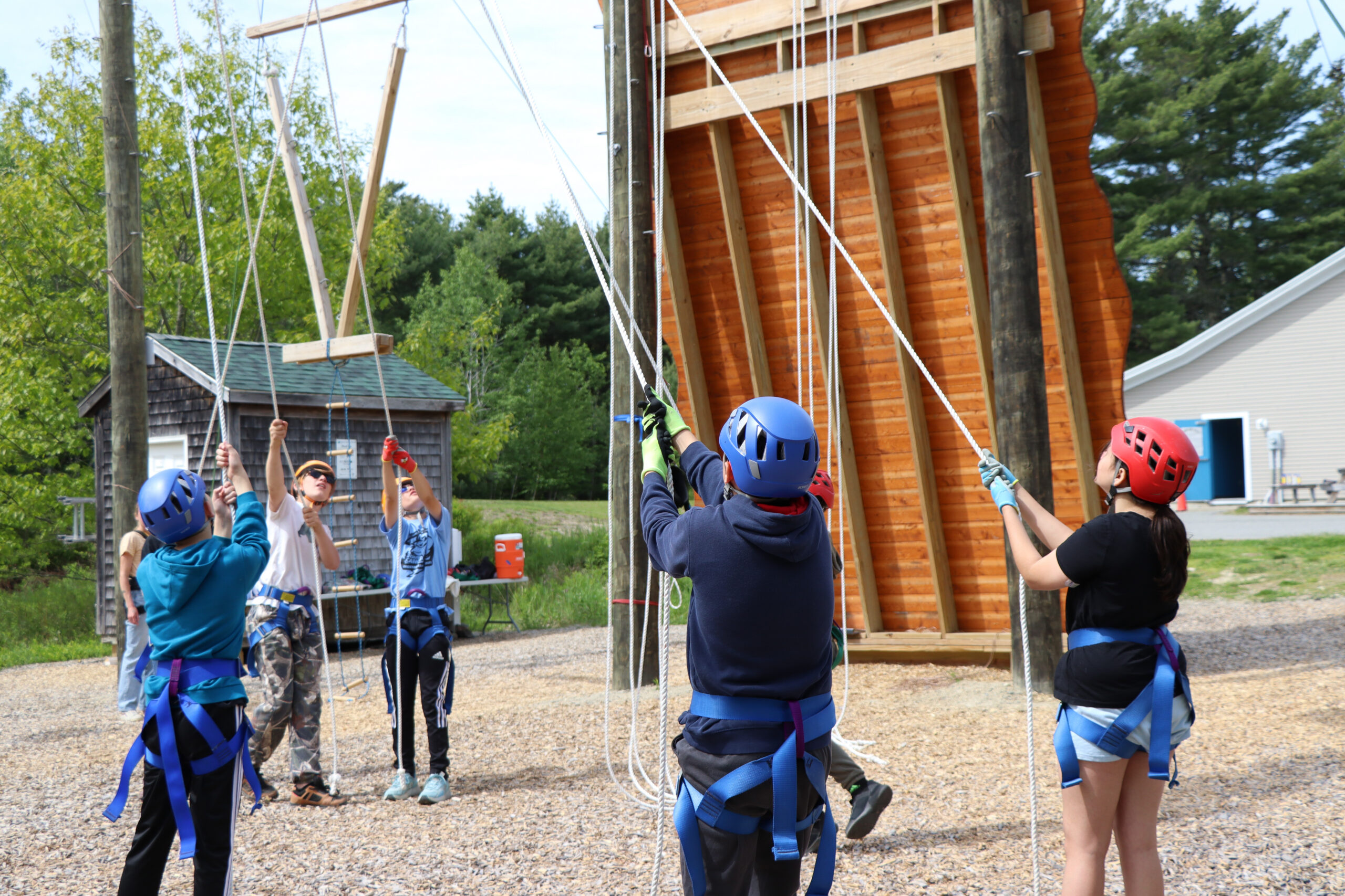 Students from RMG help out from the ground of the challenge course 