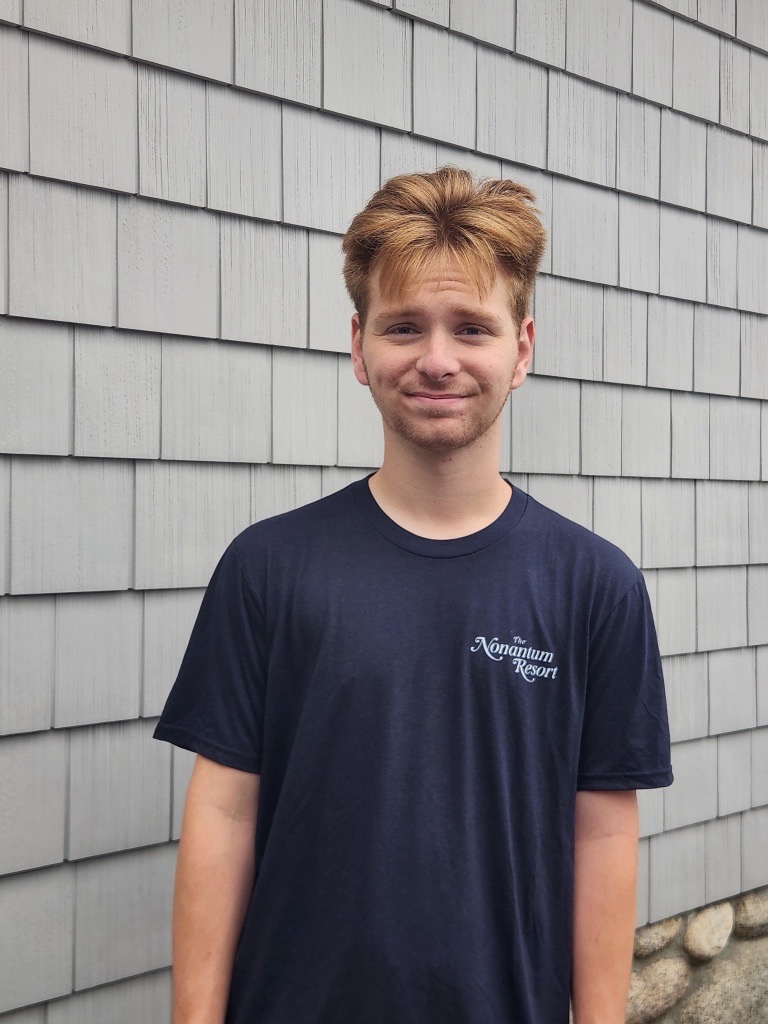 boy standing in front of shingled wall