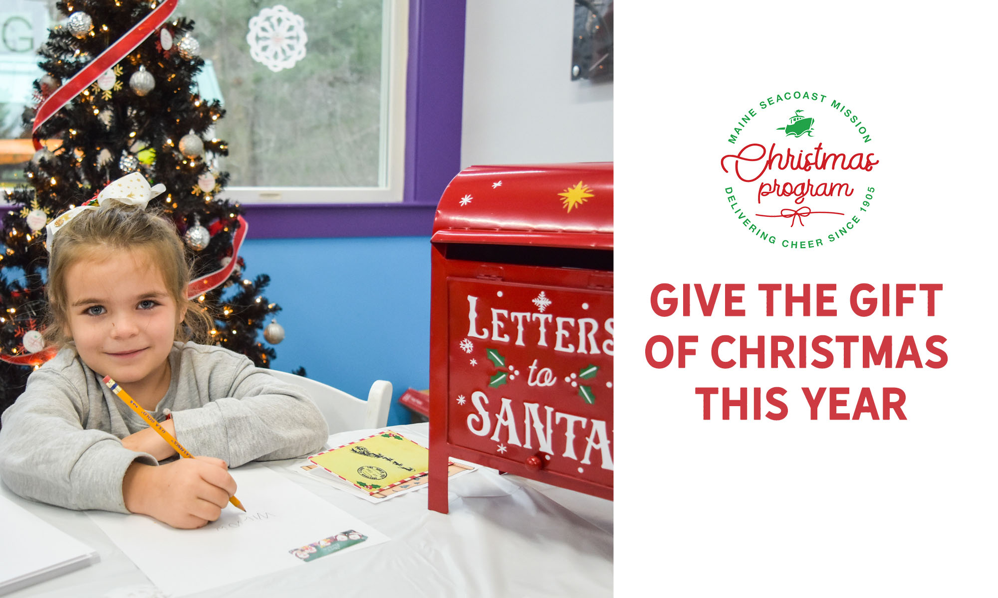 Photograph of a white child holding a pencil to write a letter. A red mailbox next to her reads Letters to Santa.