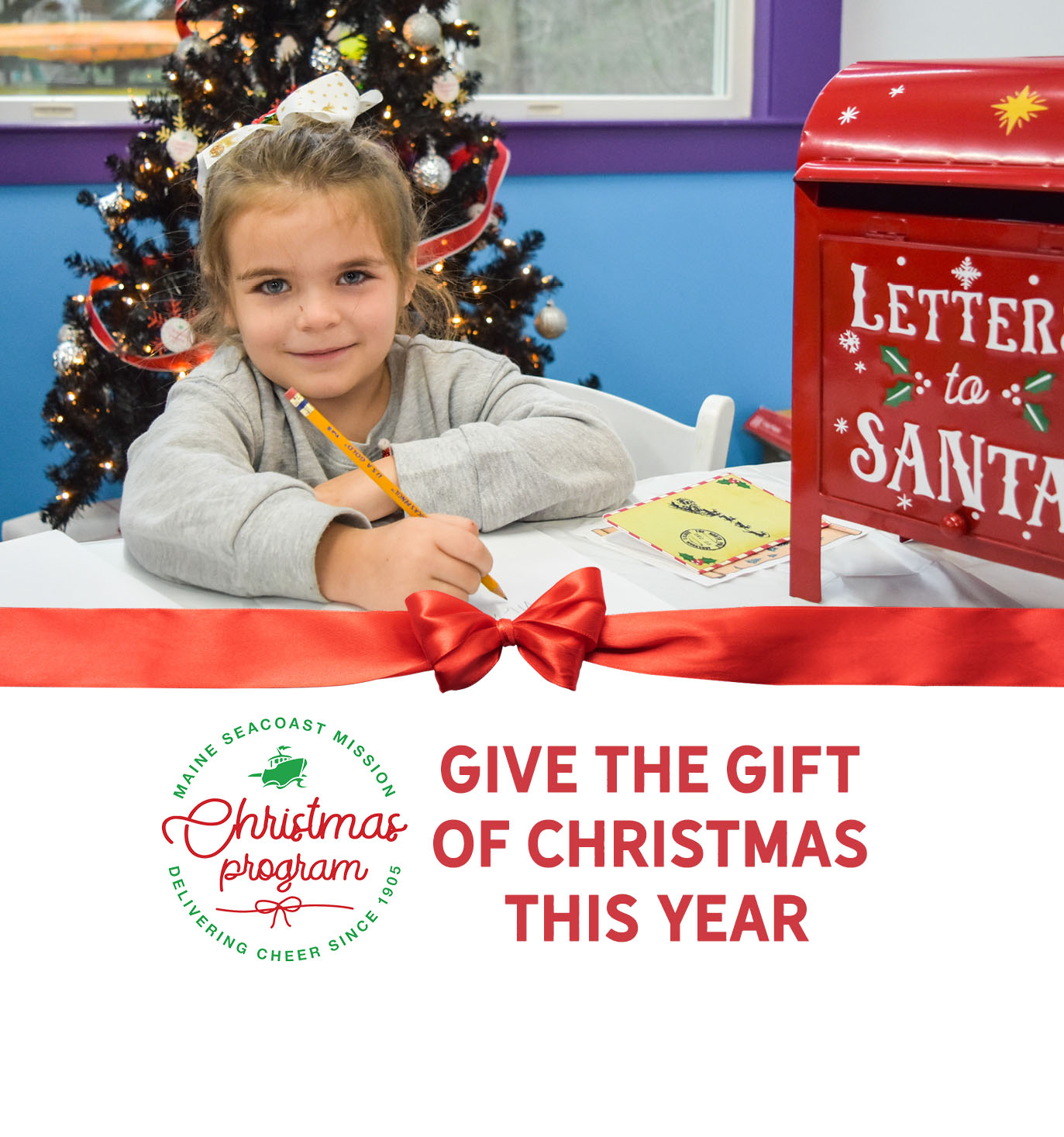 Photograph of a white child holding a pencil to write a letter. A red mailbox next to her reads Letters to Santa.